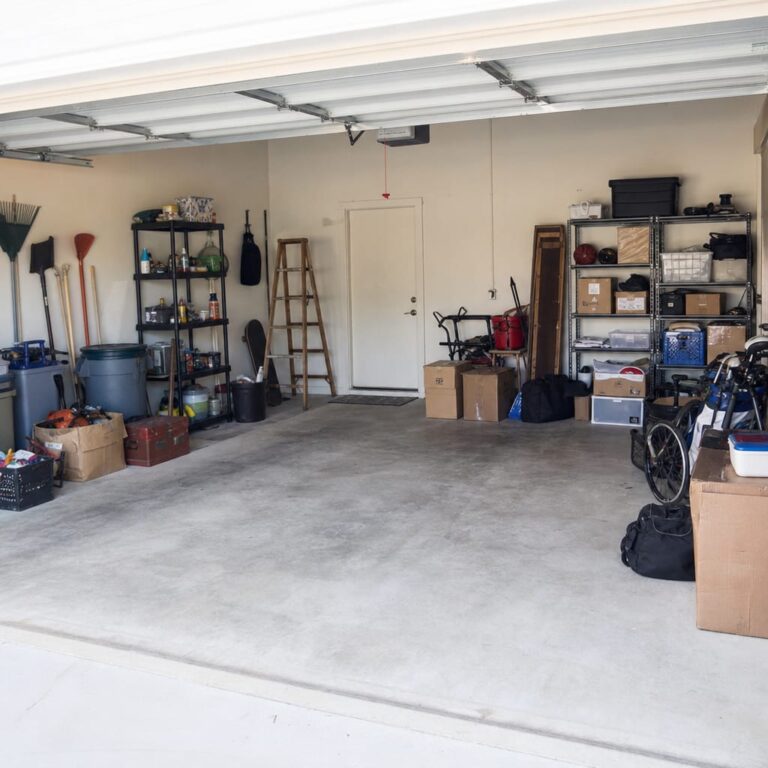 Cluttered residential garage with boxes, tools, and gear before organizing